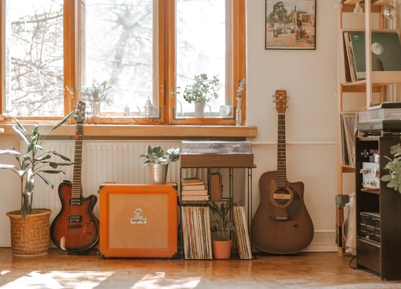 acoustic guitar, Orange amp and electric guitar in the room.